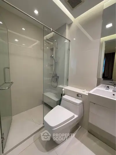 Modern bathroom with glass shower and sleek fixtures in a contemporary apartment.