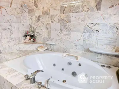 Luxurious marble bathroom with elegant jacuzzi tub and floral decor