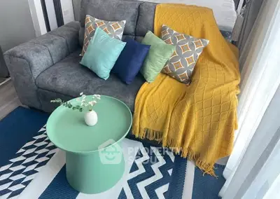 Stylish living room with modern sofa, vibrant cushions, and chic coffee table.