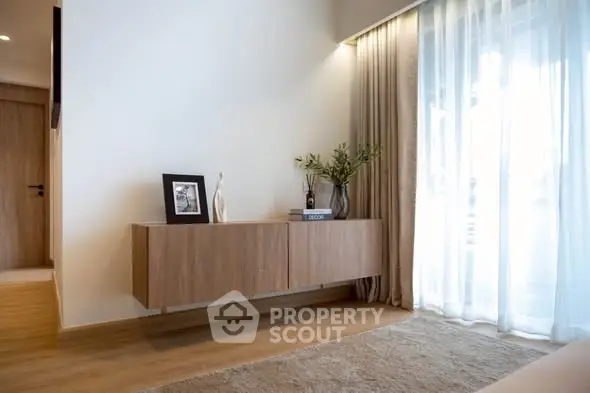 Modern living room with elegant wooden furniture and large window drapes.