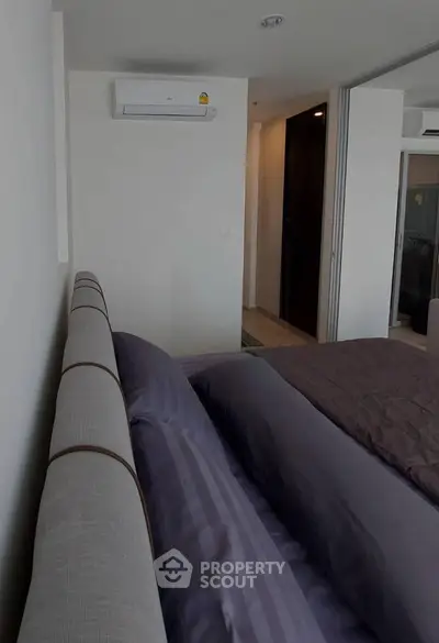 Modern bedroom with air conditioning and stylish bedding in a contemporary apartment.