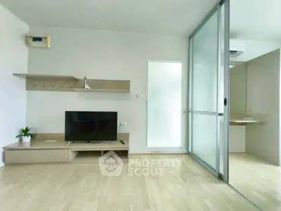 Modern living room with sleek design and sliding glass partition in a stylish apartment.
