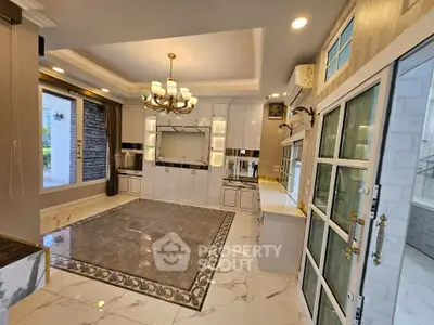 Luxurious modern kitchen with elegant chandelier and marble flooring
