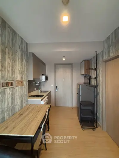 Modern kitchen with wooden flooring and stylish dining area in a contemporary apartment.