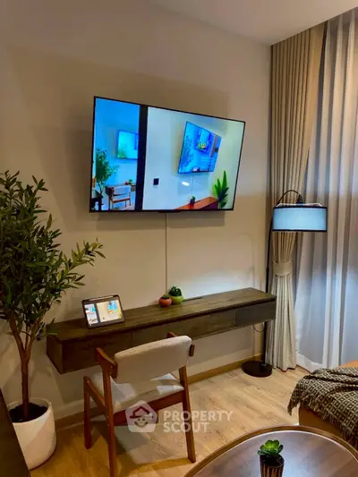 Modern living room with wall-mounted TV, stylish furniture, and elegant decor.