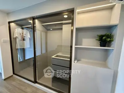 Modern bedroom with sleek built-in wardrobe and open shelving, featuring minimalist design and ample storage space.