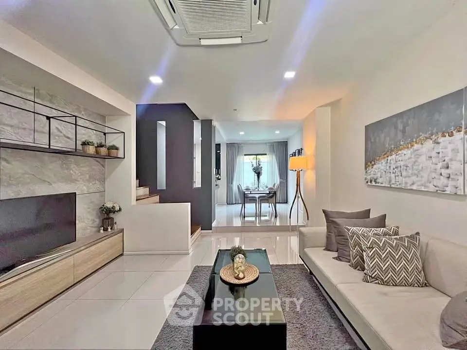 Modern living room with stylish decor and open layout, featuring a cozy seating area and elegant dining space.