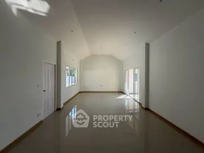 Spacious empty room with high ceiling and large windows