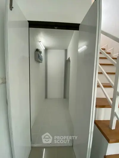 Modern minimalist hallway with white walls and staircase, perfect for contemporary living.