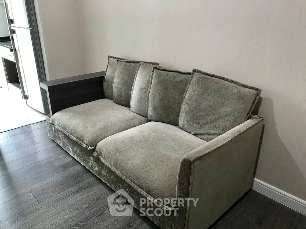 Modern living room with plush gray sofa and sleek wooden flooring