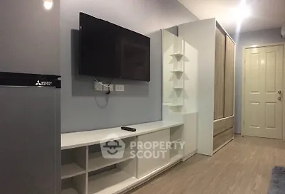 Modern living room with wall-mounted TV and sleek storage solutions.