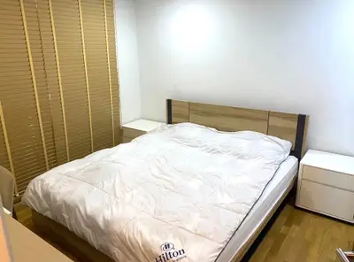 Cozy bedroom with modern wooden furniture and a comfortable bed, perfect for relaxation.