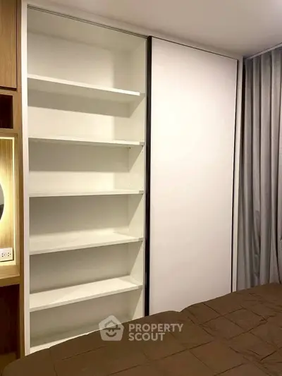 Modern bedroom with built-in shelving and cozy brown bedding