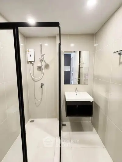 Modern bathroom with sleek shower enclosure and stylish vanity in contemporary apartment.