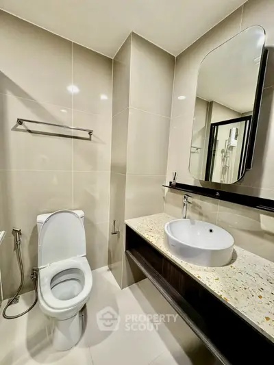 Modern bathroom with sleek fixtures and elegant design, featuring a stylish sink and toilet.