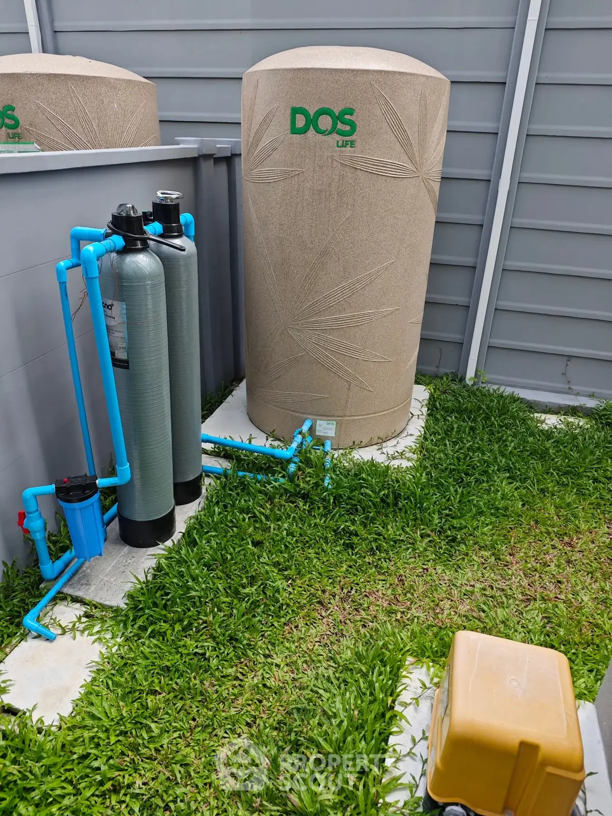 Outdoor water filtration system with storage tank in a modern garden setting.