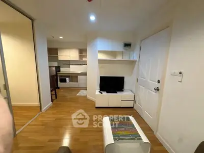 Modern living room with open kitchen and wooden flooring in a cozy apartment.