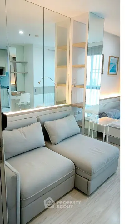 Modern living room with stylish sofa and mirrored wall in a bright apartment.