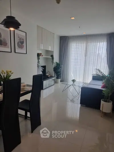 Modern living room with sleek furniture and large windows offering natural light.