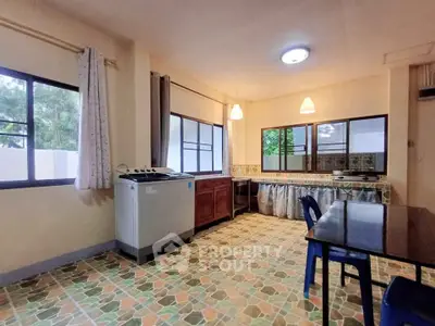 Spacious kitchen with tiled floor and ample natural light