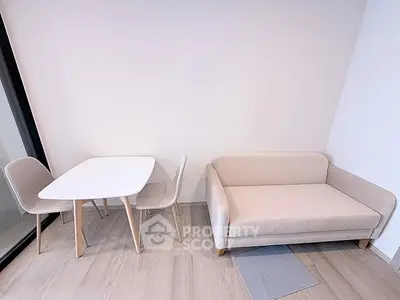 Modern minimalist living room with cozy beige sofa and sleek dining table set.