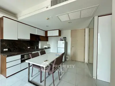 Modern kitchen with sleek cabinetry and dining area in a stylish apartment.