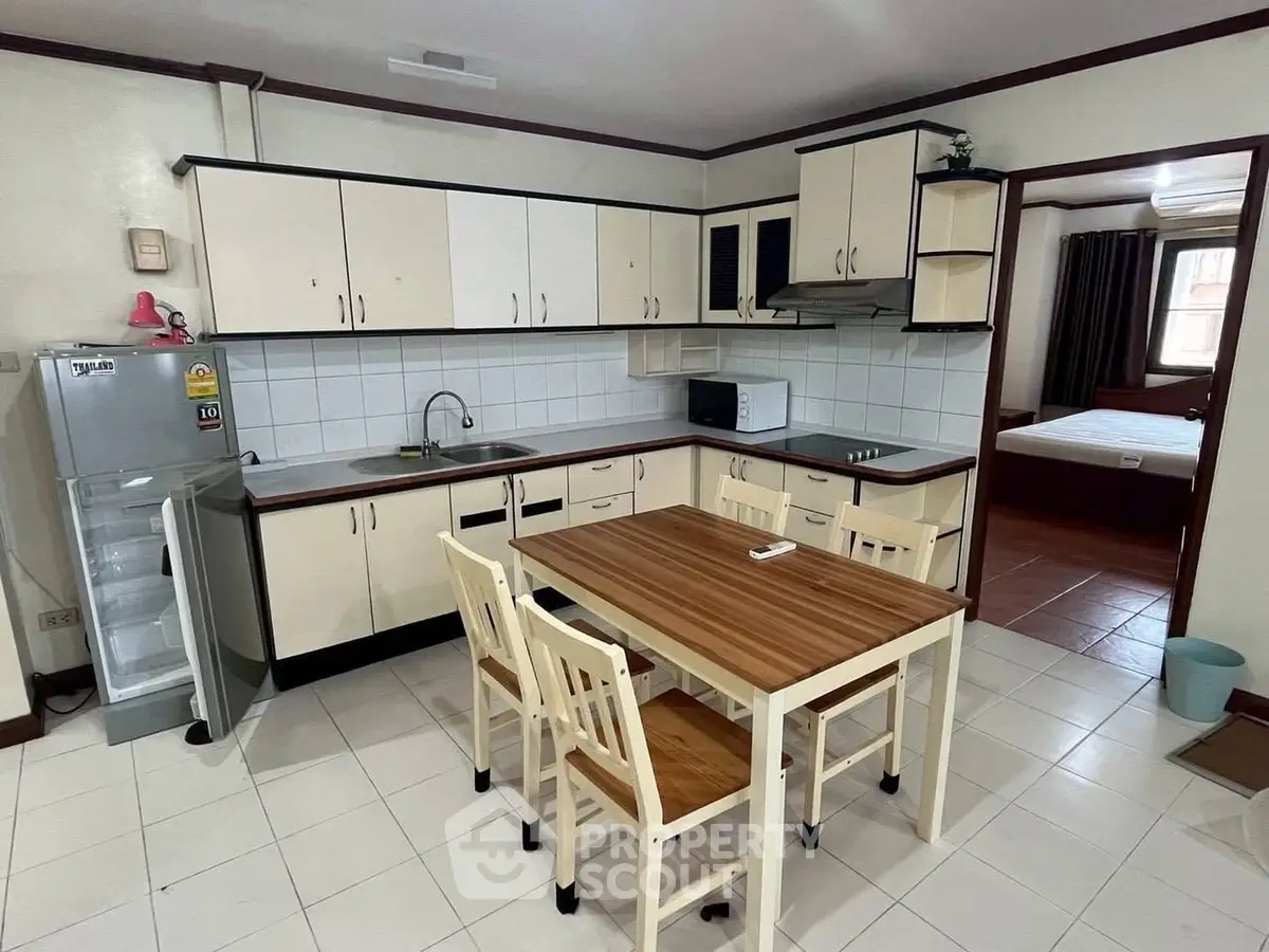 Spacious kitchen with dining area and modern appliances in a cozy apartment