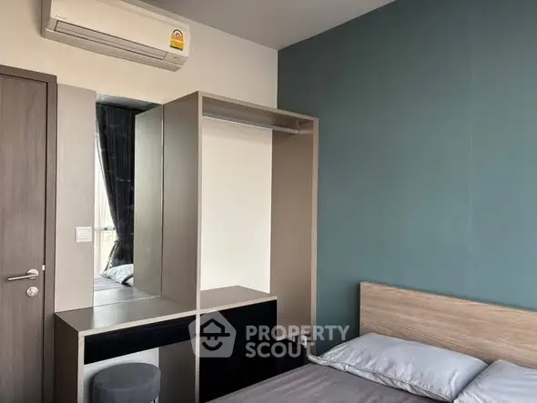 Modern bedroom with sleek wardrobe and air conditioning in a stylish apartment.