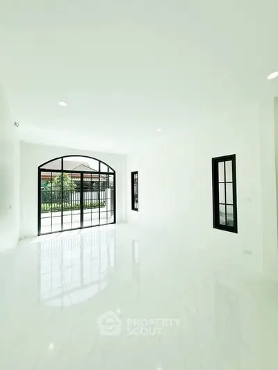 Spacious and bright living room with large windows and elegant flooring