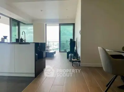 Modern open-plan living area with sleek kitchen and balcony view