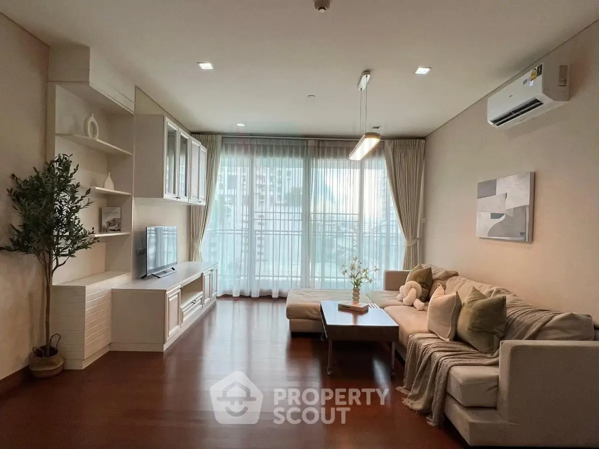 Spacious living room with modern decor and large windows in a stylish apartment.