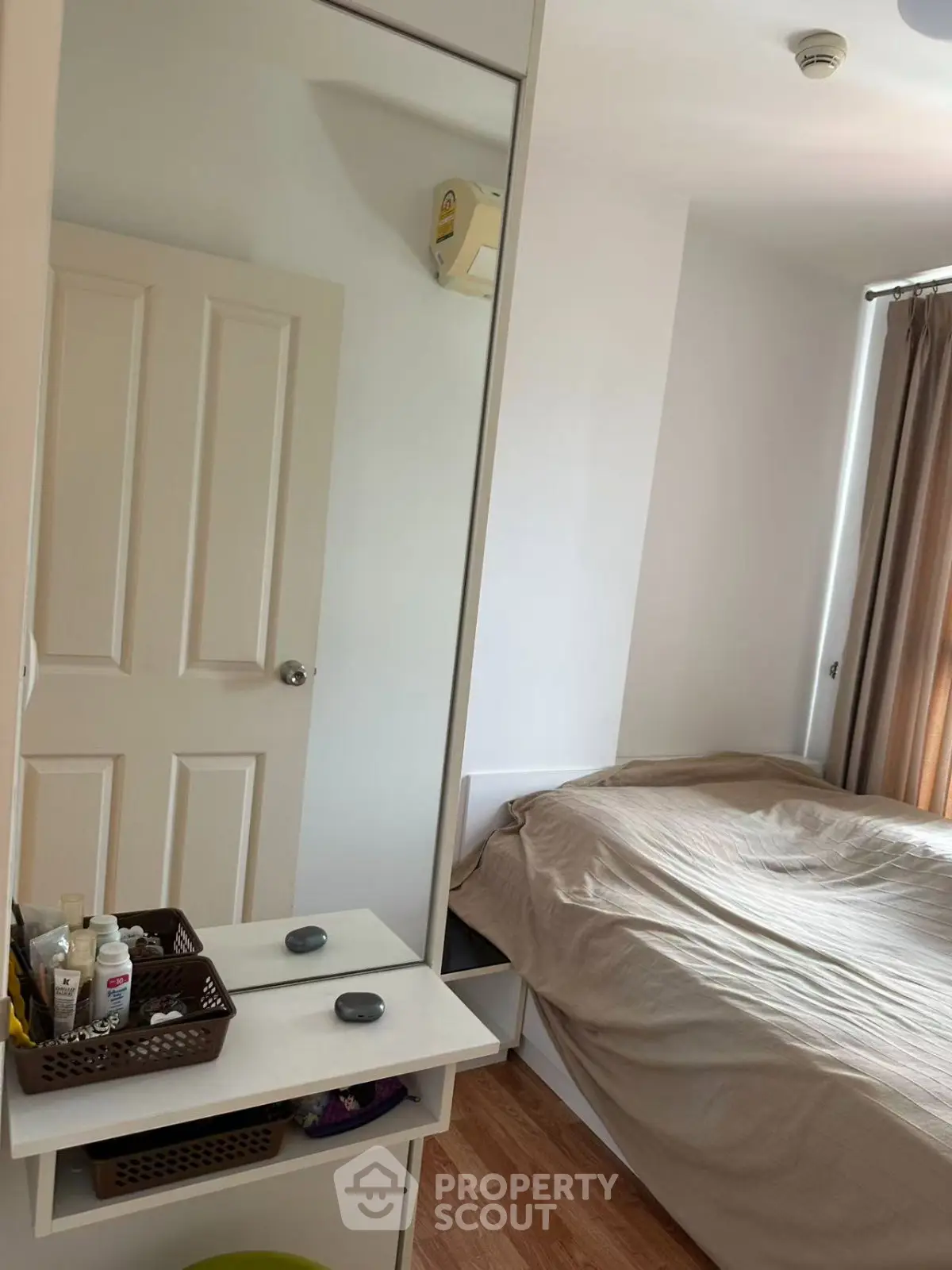 Cozy bedroom with mirror wardrobe and natural light