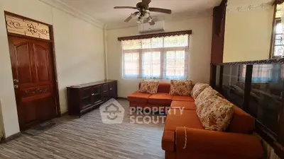 Charming living room with cozy orange sofa and elegant wooden decor