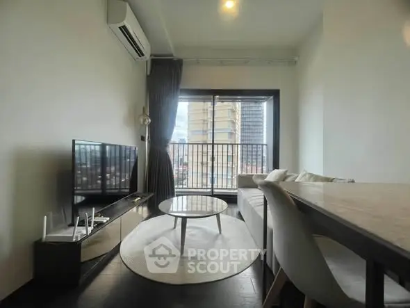 Modern living room with sleek furniture and city view through large window.