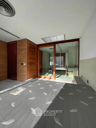 Spacious modern living room with wooden accents and large sliding glass doors.