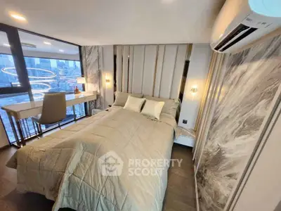 Luxurious bedroom with modern decor and stunning city view, featuring elegant lighting and a cozy workspace.