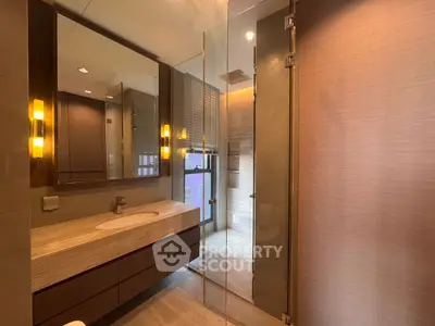 Luxurious modern bathroom with elegant lighting and spacious shower area.