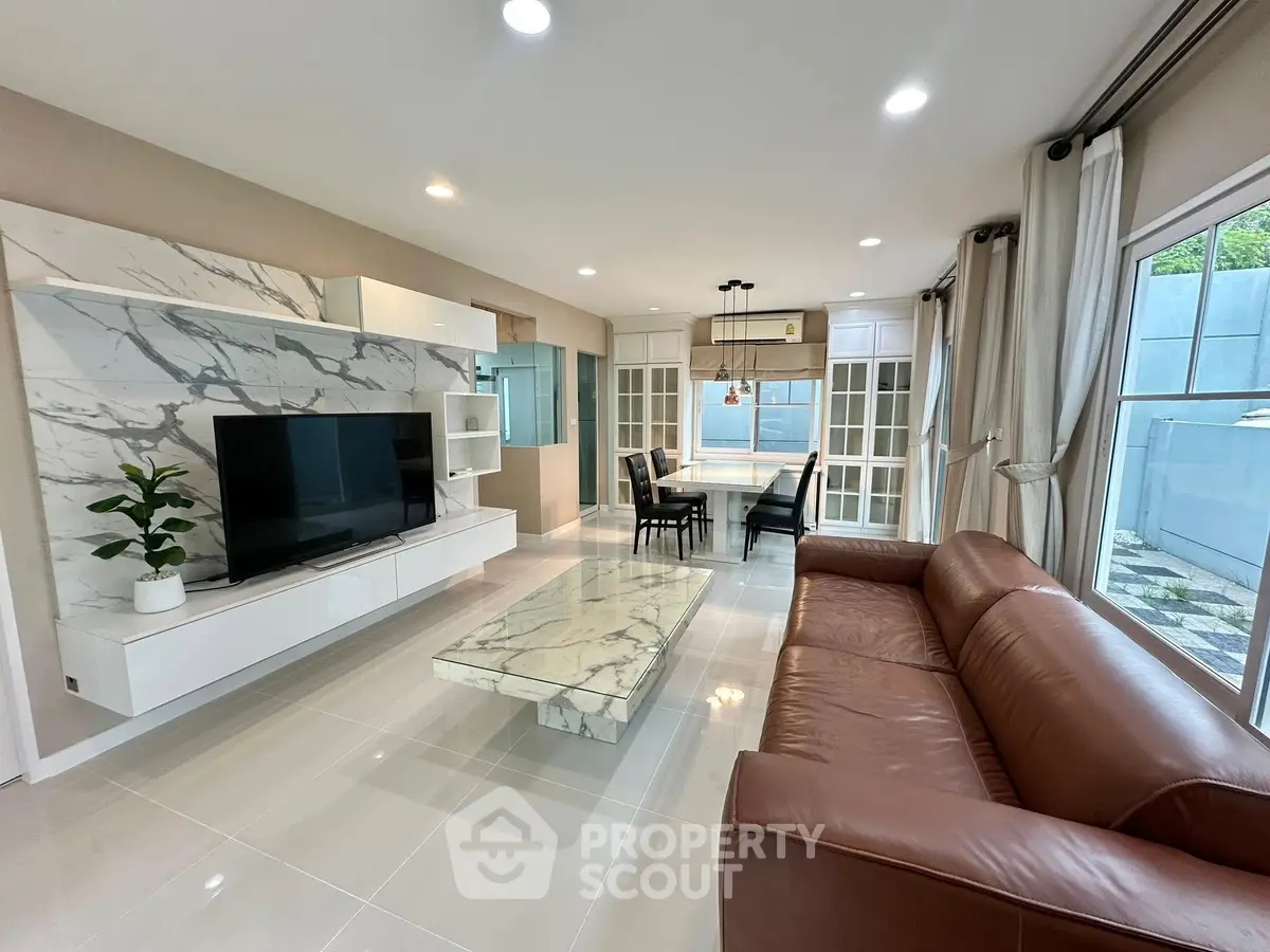 Spacious modern living room with marble accents and large windows for natural light.