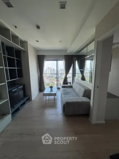 Modern living room with city view, featuring sleek furniture and large windows for natural light.