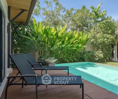 Luxurious private pool with lush greenery and modern deck chairs, perfect for relaxation and leisure.