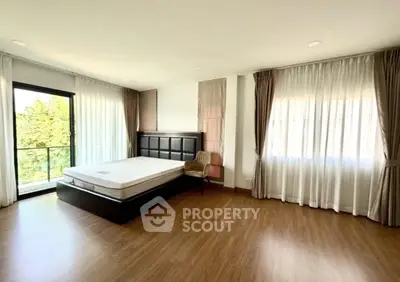 Spacious bedroom with large windows and natural light in modern apartment