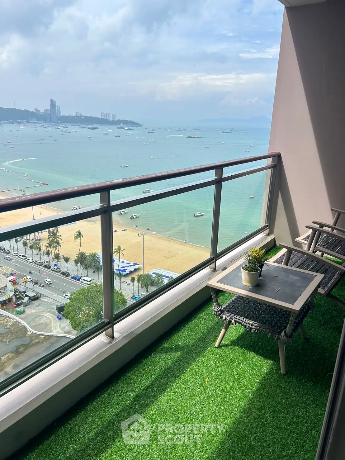 Stunning beachfront balcony with panoramic ocean views and cozy seating area.