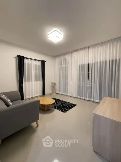 Modern living room with sleek furniture and large windows