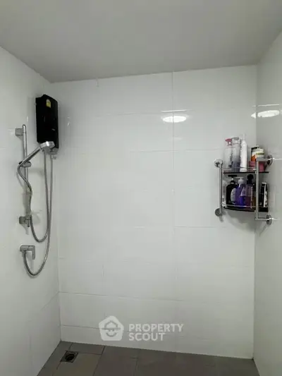Modern bathroom with sleek shower and wall-mounted toiletries rack.