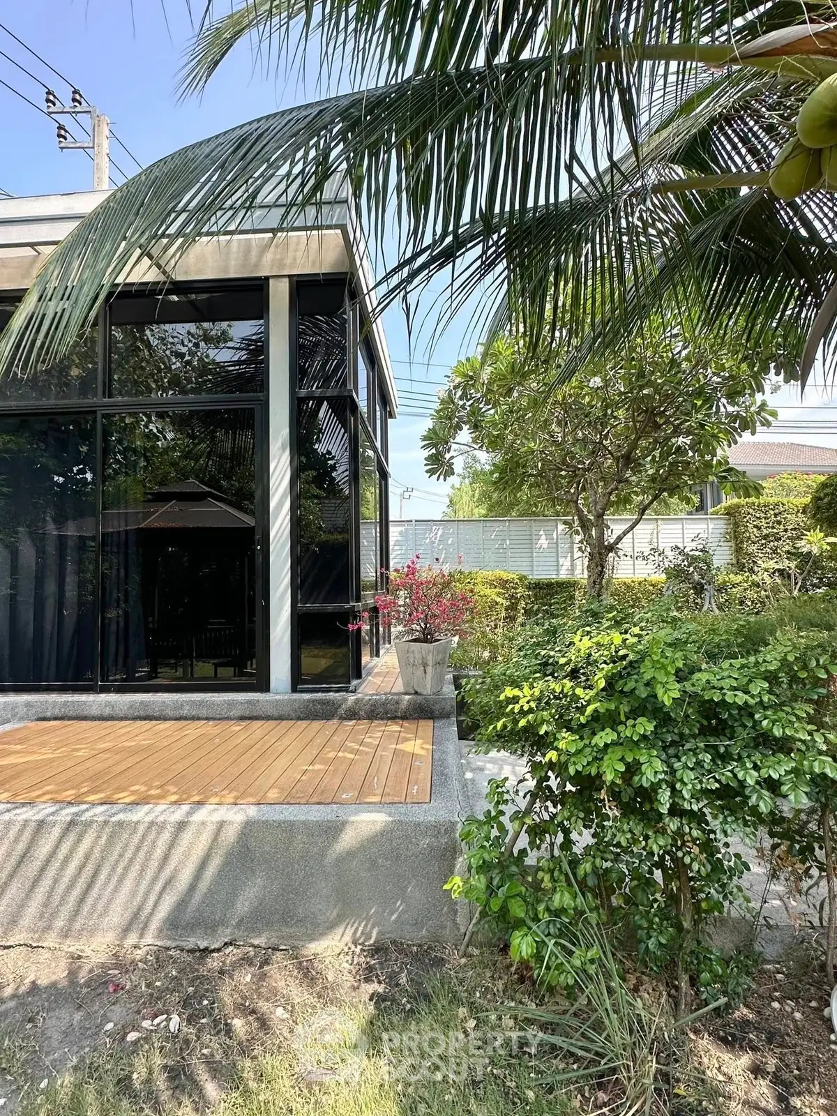 Modern home exterior with lush garden and large windows, perfect for nature lovers seeking tranquility.