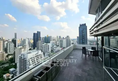 Stunning cityscape view from a spacious high-rise balcony with outdoor seating.