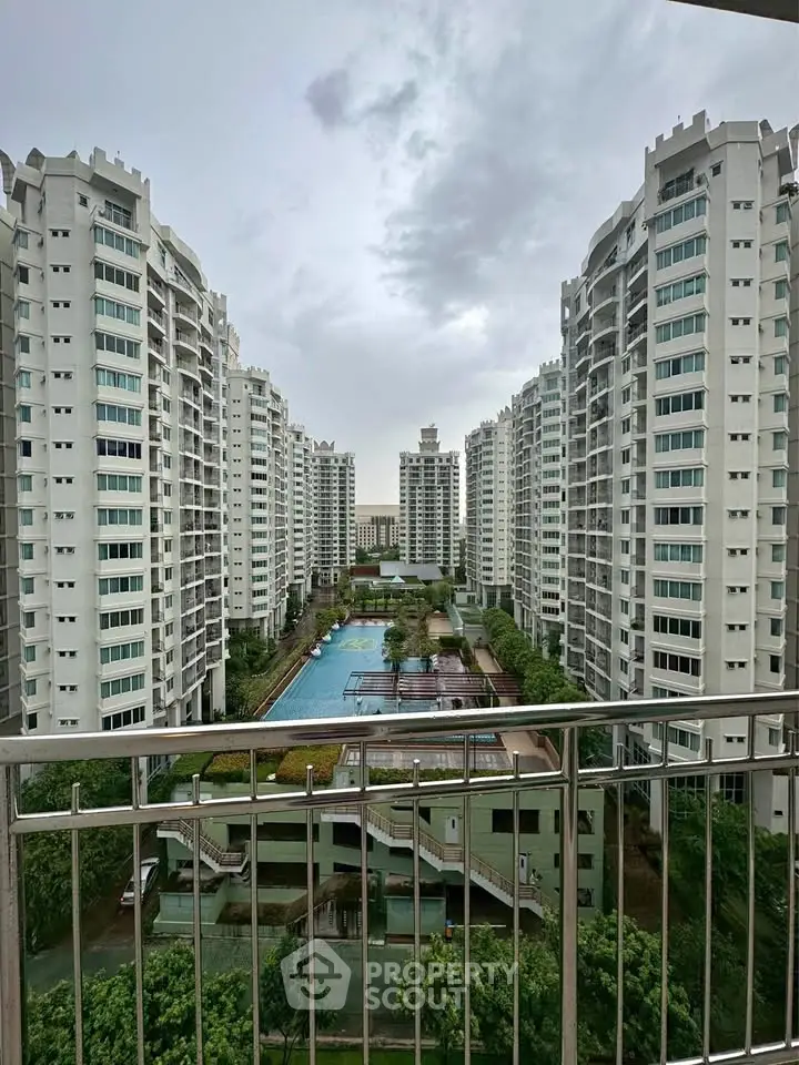 Stunning view of modern high-rise residential buildings with a central swimming pool and lush greenery.