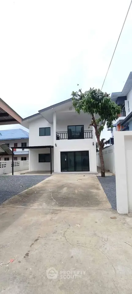 Modern two-story house with driveway and balcony in a suburban neighborhood
