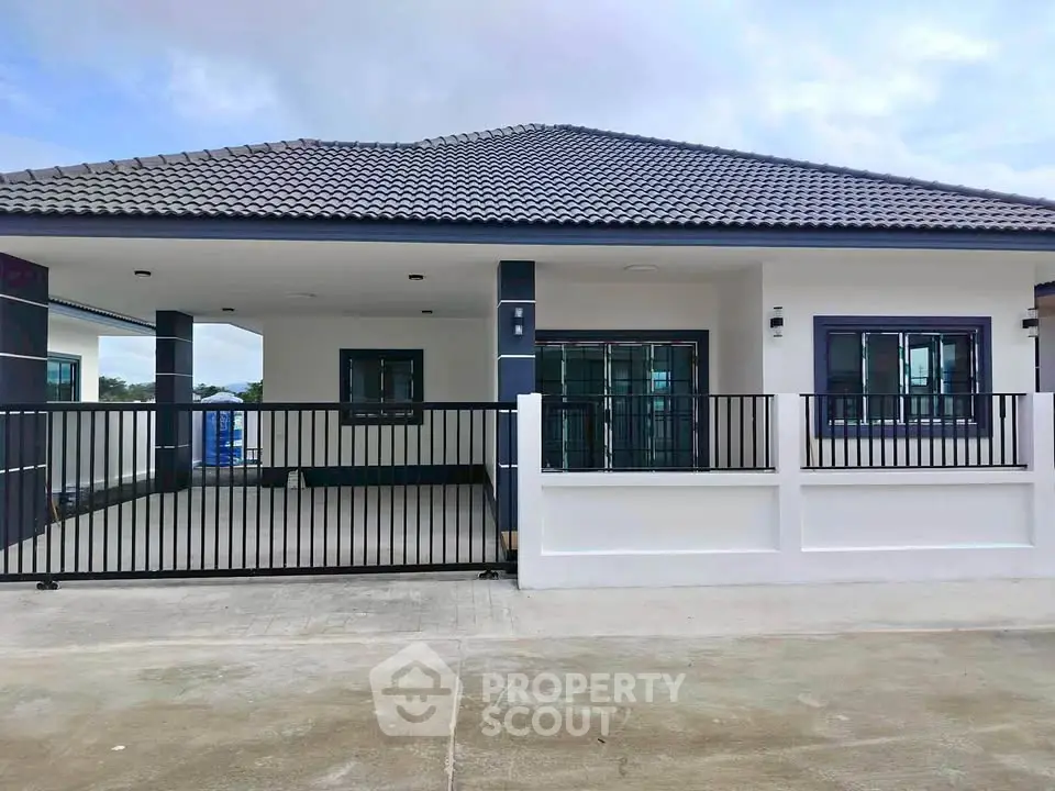 Modern single-story house with sleek design and spacious driveway.