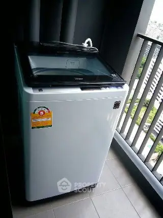 Modern washing machine on a high-rise balcony with city view